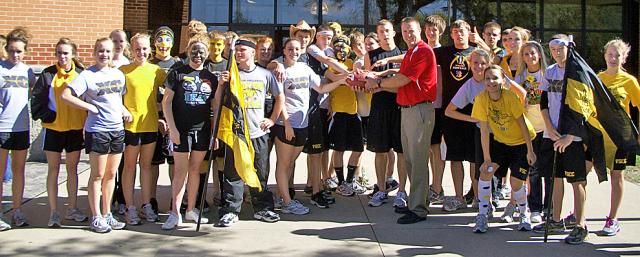 The VS Cross Country team accepts game ball from Marion coach before leaving for Vinton Friday.