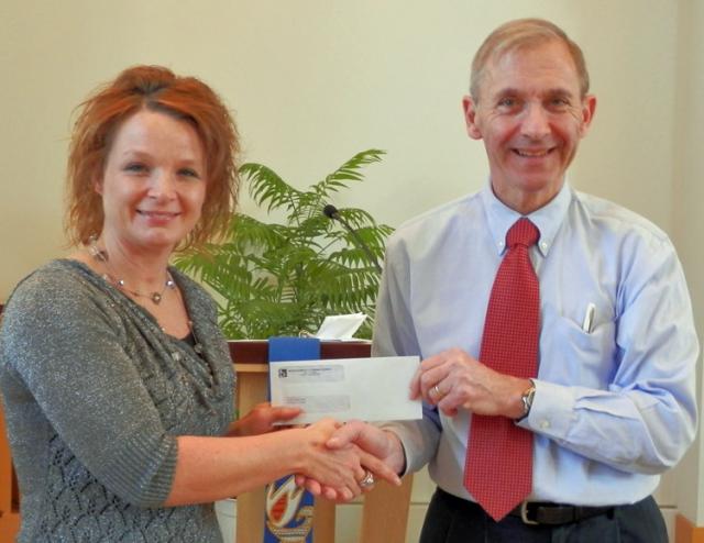 Randi Walker of ECHO Ministries receives the $101 check from George Bauer.