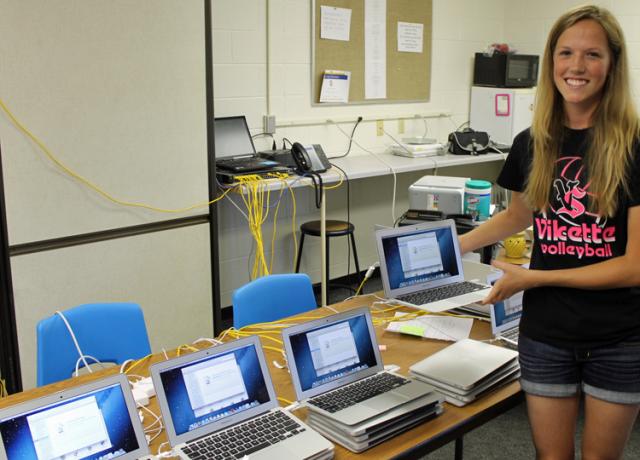 VSHS Byte Squad volunteer Grace Milroy holds the laptop she will use during its software download.