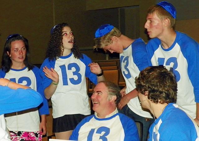 '13' cast members gather around Steve Arnold after their final dress rehearsal in August.