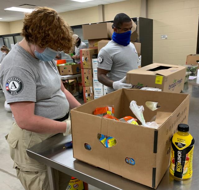 NCCC members Abby and Elijah are dividing good food from bad at the food bank.