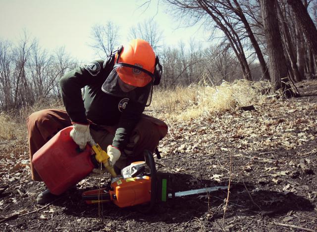 During a day of invasive species removal, Team Leader Elizabeth Siliato refueled the chainsaw.