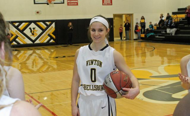 Maci Griffith's teammates applaud after giving her a signed basketball marking her 1,000th point.