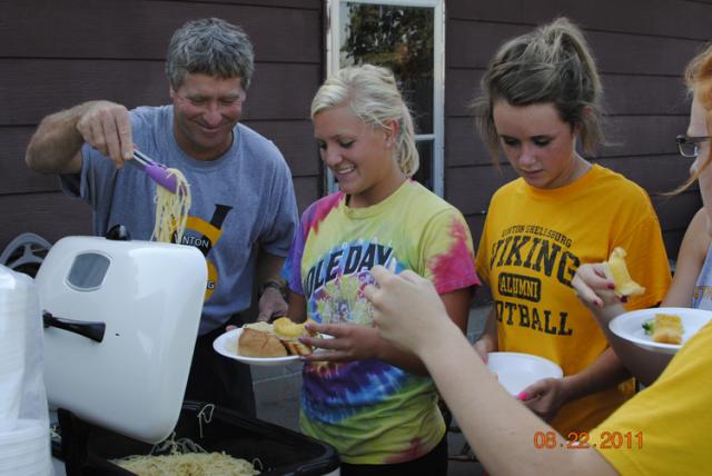 Coach Frazier dishes up the sauce for Srs. Emma Horst and Danesha Pladsen