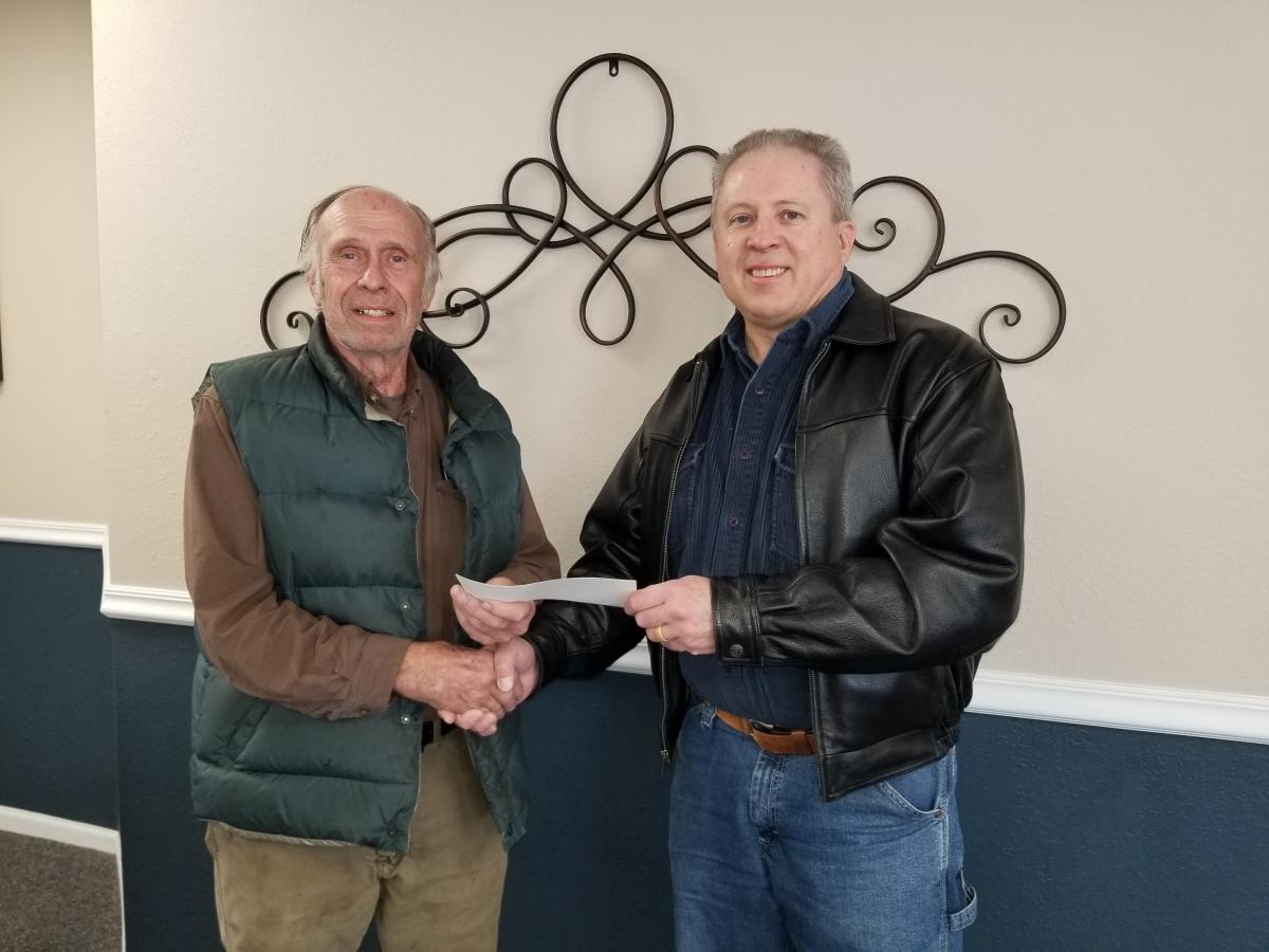 Dave Henkel presents a $1,000 check to State Representative Tom Gerhold on behalf of FUELIowa