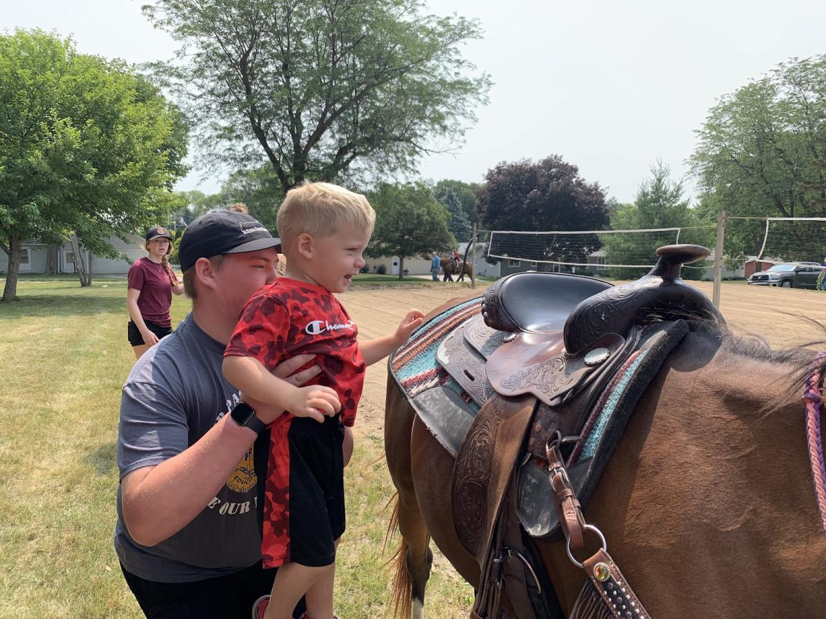 Members like Will McKenna helped small children get on and stay safe during the horse rides.