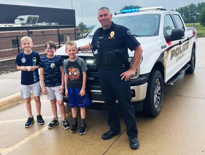 Article Thumbnail. Urbana Police Chief with a few of the area children