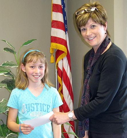 Emma DIckinson receives a $100 check from Sue Hammond; Emma won the