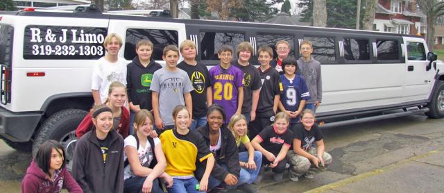 Seventh grade students who sold 10 or more subscriptions pose near the limousine.