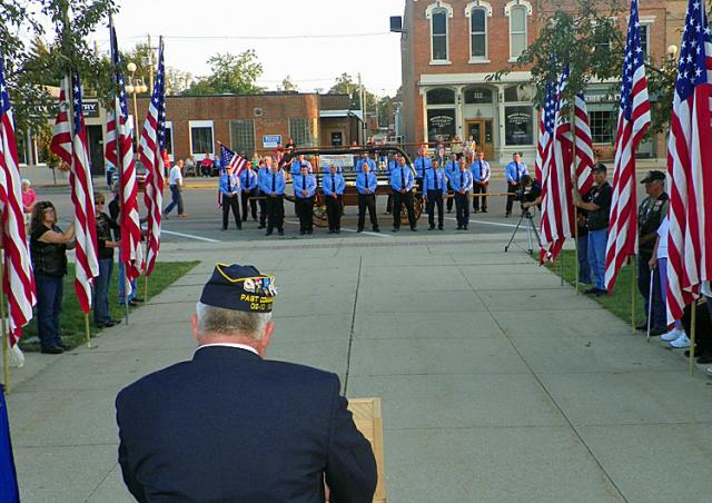 Flags and firemen line the sidewalk for the 9/11 memorial ceremony in Vinton, Sunday.