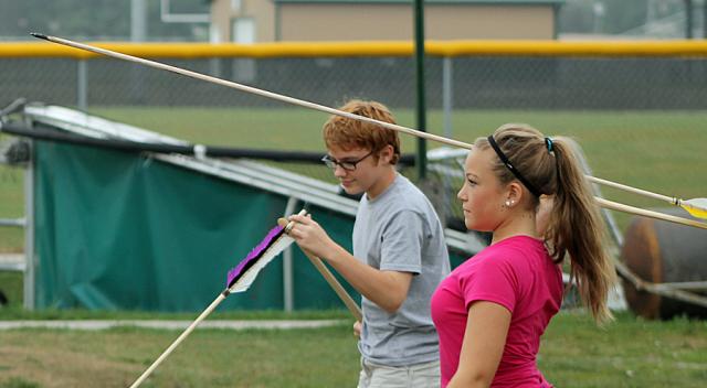 Brandi Gerber uses an atlatl to toss a dart.