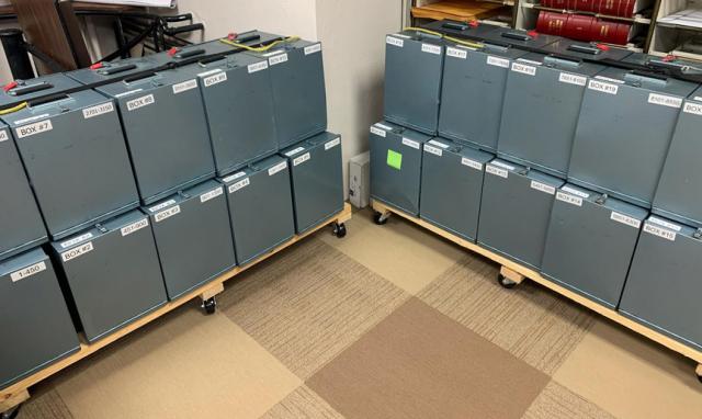 Boxes that used to carry ballots from the polling place are now used to store absentee ballots.