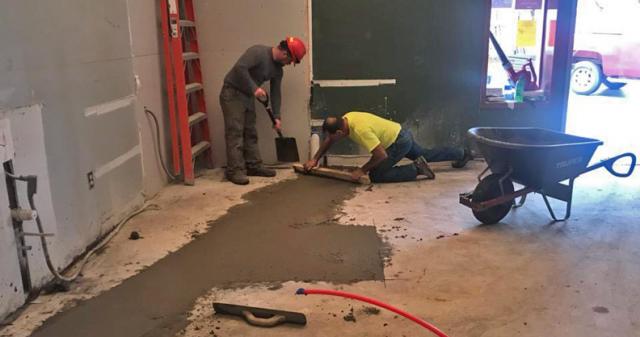 Allan Merchant smoothing out the cement in the Palace concession area as the Palace updates