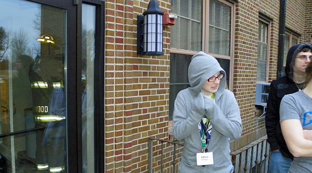 Allison O'Shea and other AmeriCorps members wait for firemen to reset the fire alarm Saturday.