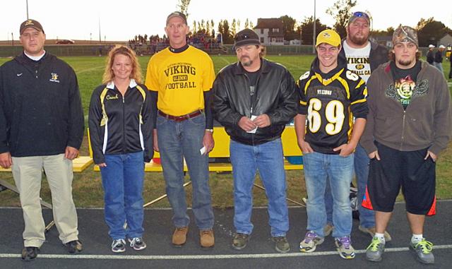 Randy Scheel and other alumni players presented checks to coaches Pat Farley and Randi Walker.