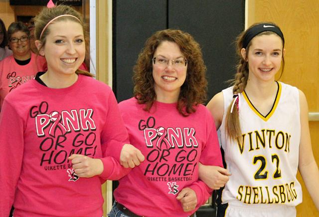 Vikettes Emily H-V and Bethany Miller escort cancer survivor Angie Tharp during Pink Night.