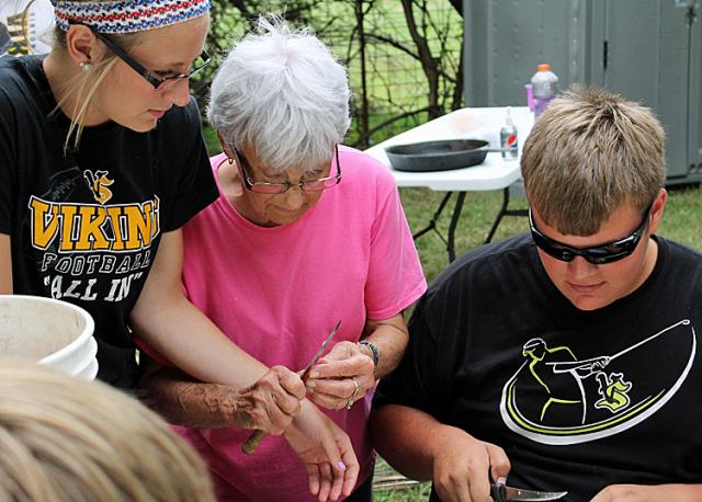 Ann Womochil helps granddaughter Devin and Viking players with the carrots during the camp-out.