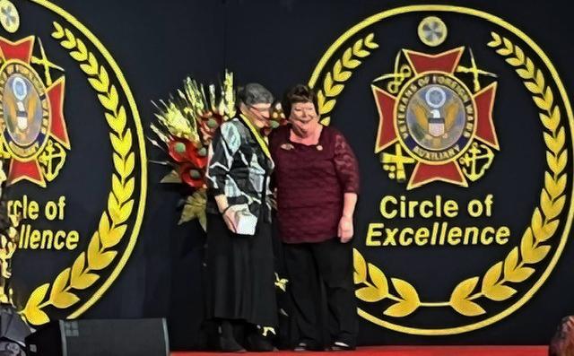 Jeanette Henry Department of Iowa VFW Auxiliary 2021-2022 President on stage receiving the Circle of Excellence Award