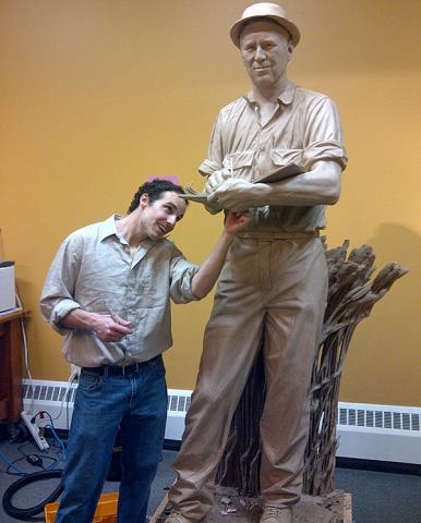 Benjamin Victor works on the Nornan Borlaug statue at the State Historical Building.