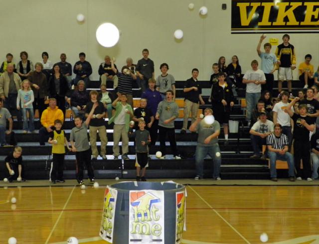 Ball toss participants aim for a target during halftime to raise funds for Dollars for Scholars.