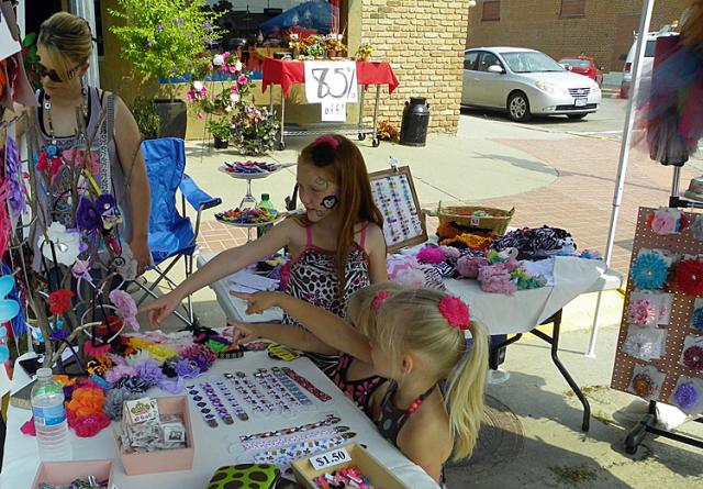Girls admire the flowers at one of the Boomfest vendor booths.