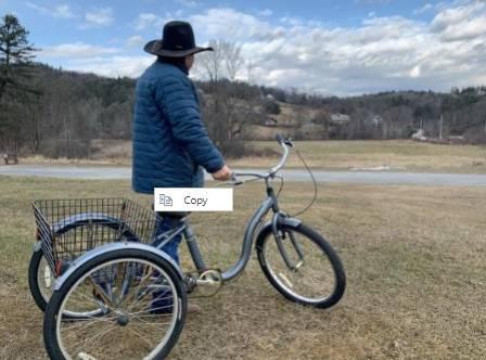 Luis surveys his surroundings with the tricycle cart his family uses to shop for groceries in nearby Keene.