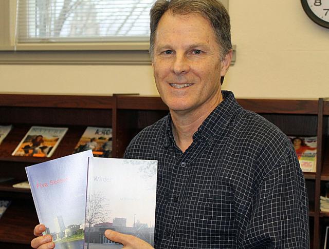 William Martin holds his two novels during a book signing at the Vinton Public Library.
