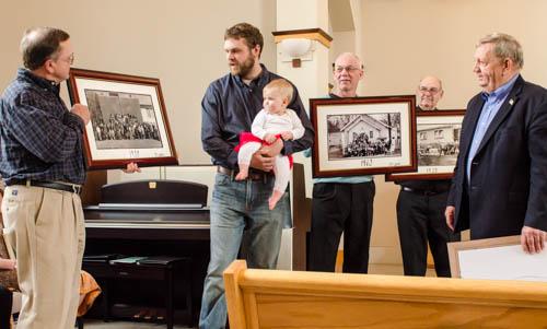 Bethlehem Lutheran members look at photos in which they appear during previous church anniversaries.