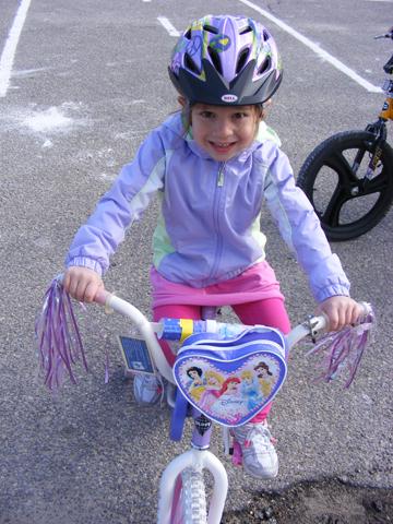 Sophia Vasquez is demonstrating proper bike safety by sporting a properly fitted helmet.