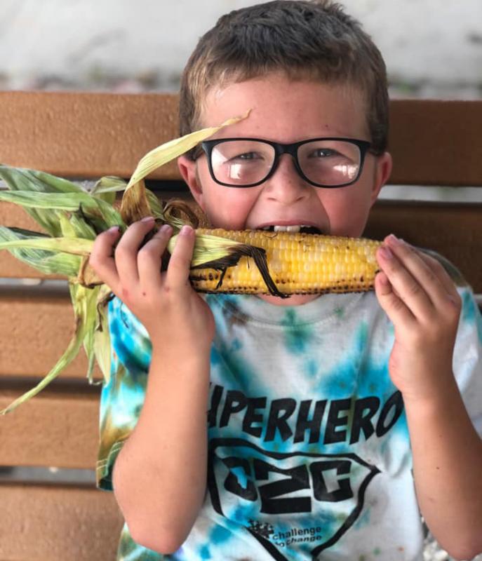 Brady Smith enjoys and ear of corn from the Garrison Farmers Market