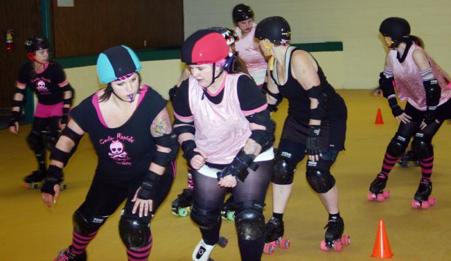 Rollergirls practice their passing and blocking at Vinton Skate Center.