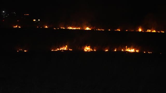 Vinton firefighters watch a controlled burn Thursday; a property owner asked them to burn the area.