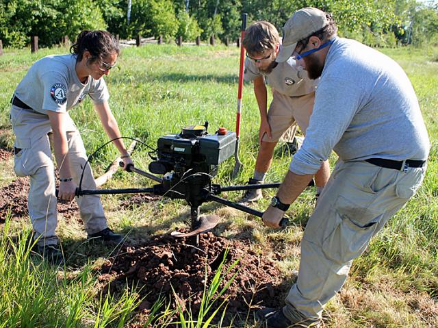 Ilexis, Daniel, and Peter work to dig 126 post holes for the fence surrounding the orchards.