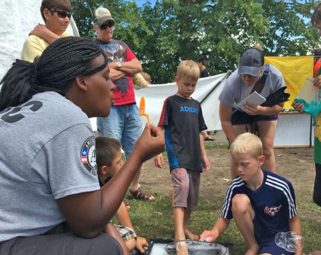 Kellye Howard teaches kids how to blow bubbles at the Dragonboat Festival.
