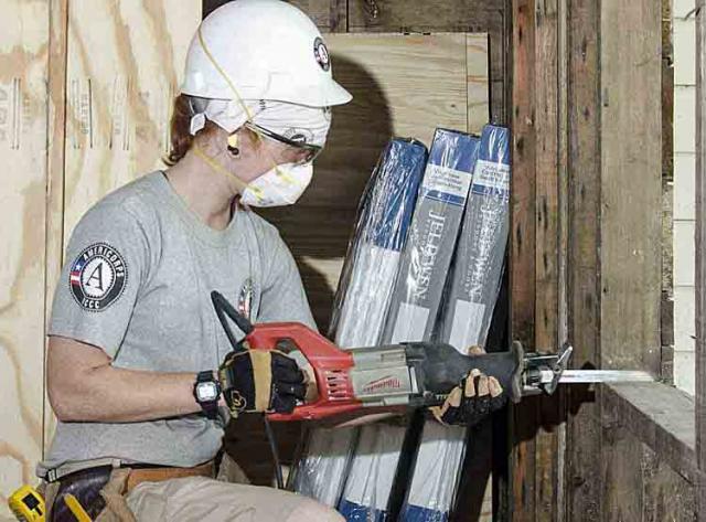 Ema Irwin cutting out a sill plate to fit a new egress window.