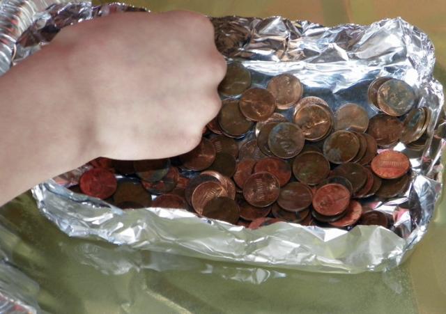 Water science: Fifth-graders see how many pennies can float in a tin foil boat.