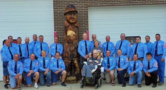 Vinton firefighters gather around Dave and Marcia Hite as they dedicate the 'Chief' sculpture.