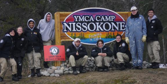 Maple 2 in front of the sign for YMCA Camp Nissokone in Oscoda, Michigan