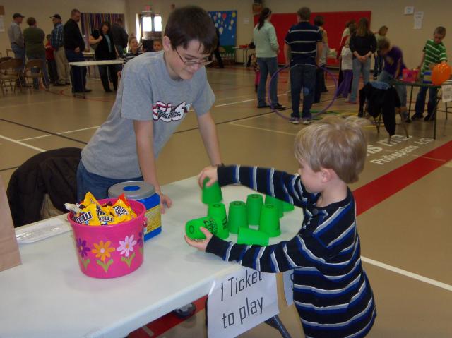 Clayton Sebetka (CLS Kindergarten) tries his hand at cup stacking with CLS 7th grader Matthew Voss.