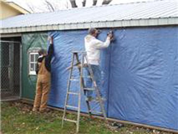 'Tis the season to make it cozy...volunteers take a few minutes to winterize the animal shelter