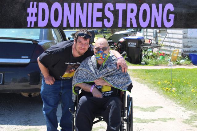 Donnie Wheeler with son Justin outside the family home as they wait for the parade to begin