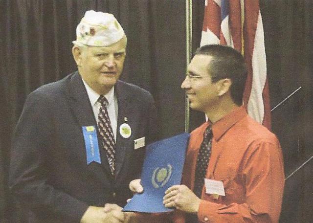 Lyle Schaffer, Past Iowa Commander, presents Alex Vasquez the 2013 Educator of the Year Award.