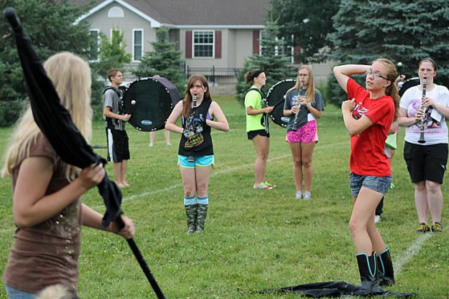 Flag Corps member Erica Noe 'pitches' during the band's rehearsal for its baseball-themed show.