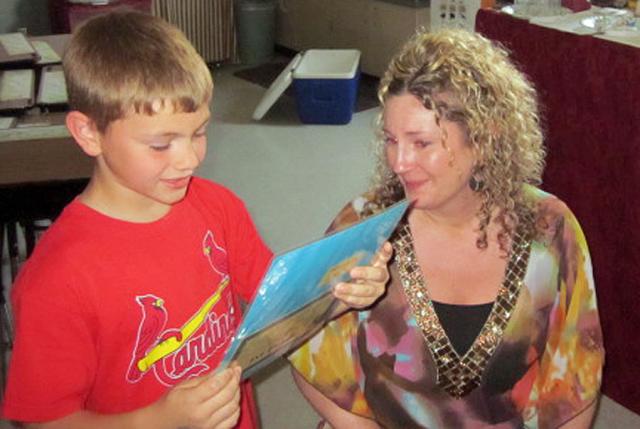 Andrea Evans cries as her son Kail reads her his first-place Mother's Day essay Friday.