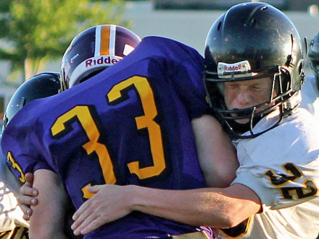 Will Edwards (32) with help from his brother, Wes (helmet at left) tackles an Oelwein runner.