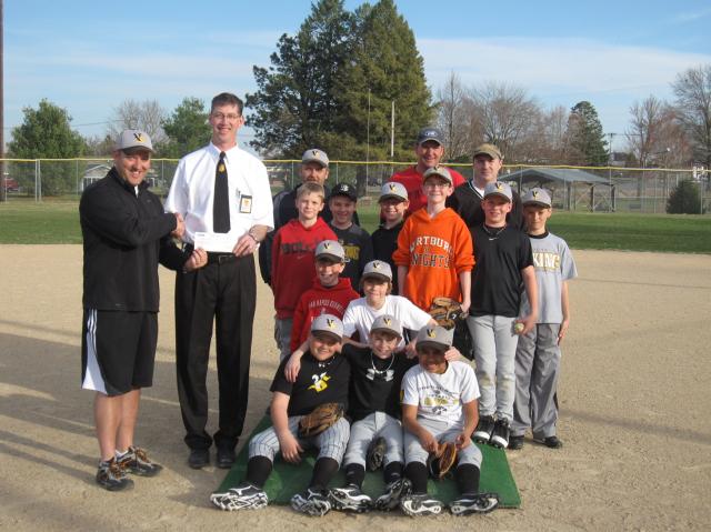Manager Dave Kelchen, Fareway, presents check to Coach Stuart Overton, asst. coaches and team.
