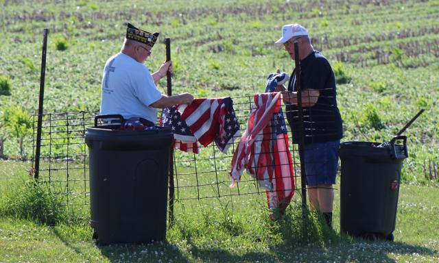 Craig Streeter and Post Commander Ron Albright drape flags set to be disposed of.