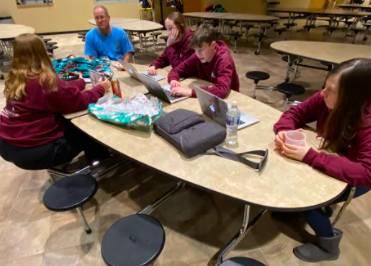 Annabelle Newton, and Paul Herger getting help from Mrs. Fleming, and Ms. Power on their Iowa Degrees