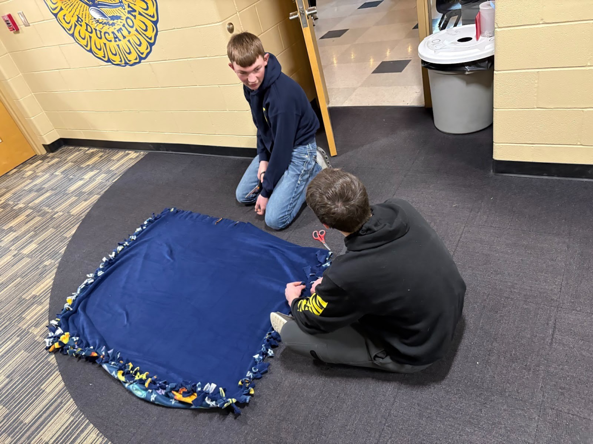 Members Will Kreutner and Carter Smith making Tie Blankets for the Children’s hospital.