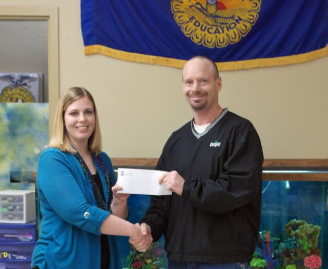 FFA advisor Louise Fleming receives the $10,500 check from Cargill rep Tom Stueck.